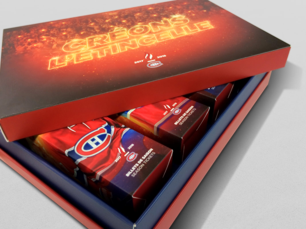 A premium suite ticket presentation box with a printed lid, opened to show boxed season ticket sets inside
